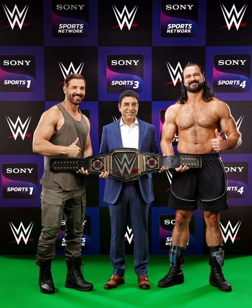 Bollywood-meets-WWE-–-Bollywood-megastar-John-Abraham-alongside-WWE-superstar-Drew-McIntyre-strikes-a-pose-with-Mr.-Rajesh-Kaul-for-the-‘WWE-100-Shudh-Sports-Entertainment-campaign